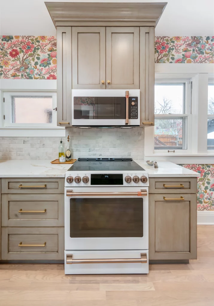 Kitchen remodel showing oven and cabinetry with floral wallpaper accent